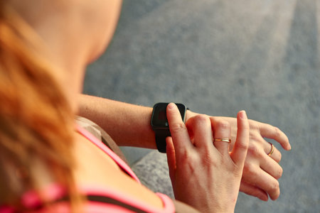 Young girl timming her workout performance with her touchscreen device and persuing fitness goals