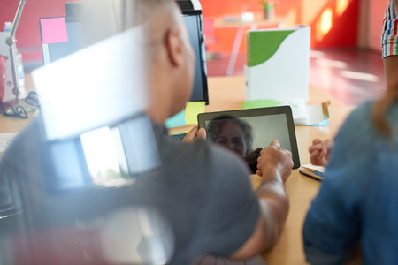 Candid picture of a business team collaborating. Filtered serie with light flares and cool tones.