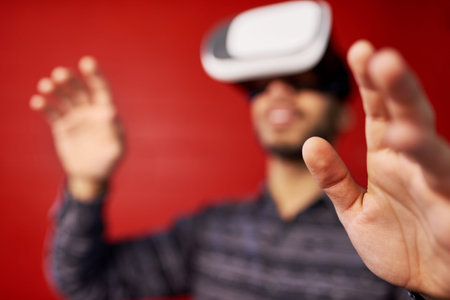 Young South Asian man learning new technology using VR glasses in a trendy warehouse loft
