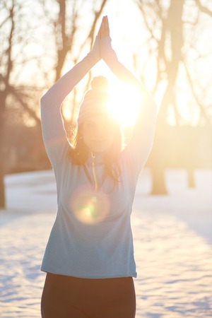 Serene lady relaxing and meditating doing yoga poses at sunsetの写真素材
