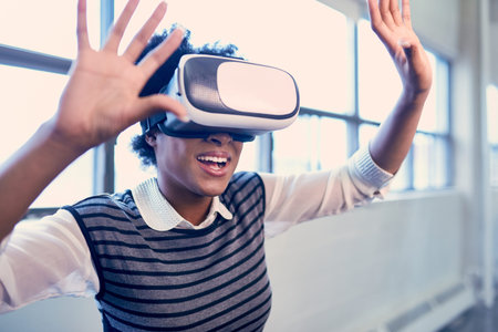 Smiling young African American woman with VR glasses reaching out and learning new technology in a...