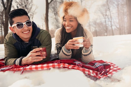Group of millenial young adult friends enjoying wintertime and in a snow filled parkの写真素材