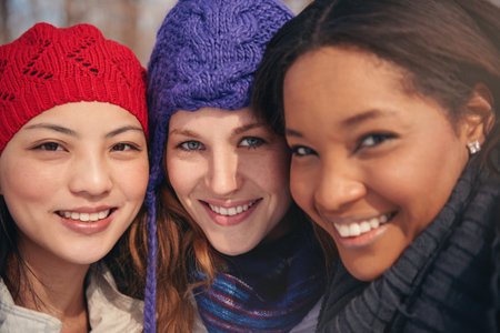 Group of girl friends enjoying taking selfies in the snow in winter