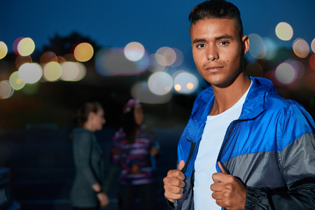 African american millennial guy looking straight at camera during a workout outdoors in a urban park late evening with friends.の写真素材