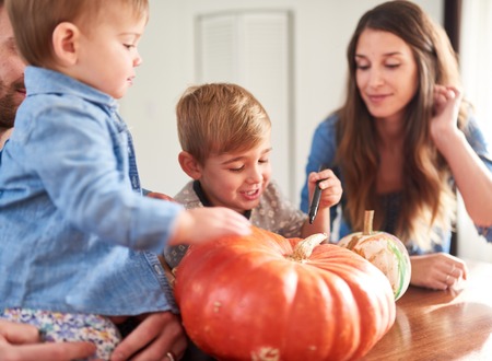 Family decorating pumpkins together for Halloweenの写真素材