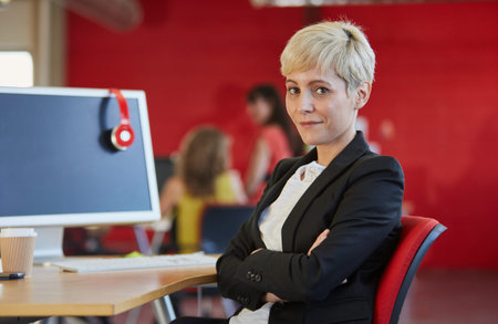 Confident female designer working in red creative office space