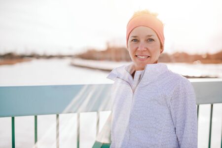 Sporty caucasian woman keeping fit in the winter and going outside in a snow filled cityの写真素材