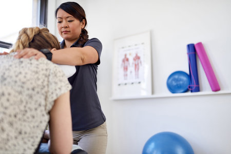 Chinese woman massage therapist giving a neck and back pressure