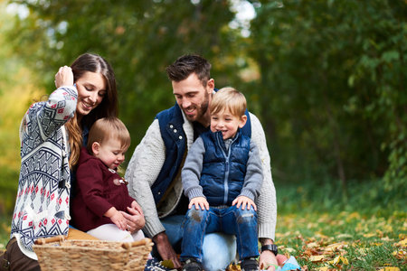 happy family with mother, father, son and daughter throwing leav