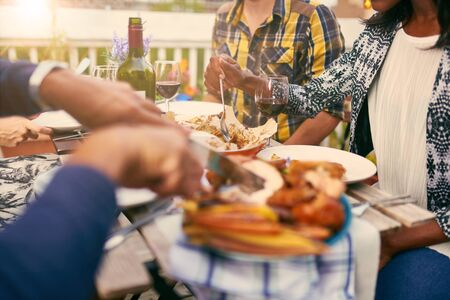 Group of diverse friends having dinner al fresco in urban settinの写真素材