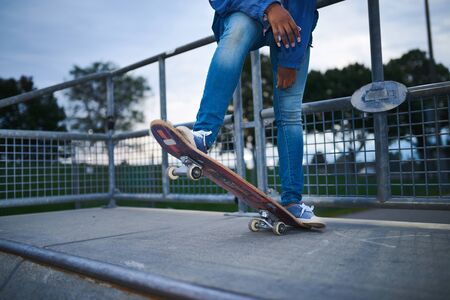 Attractive young african american woman skaterboarder sittting oの写真素材