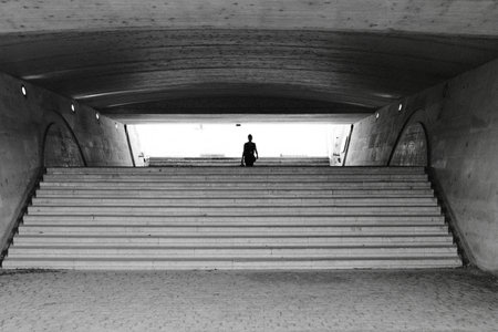 Silhouette of a man walking up the stairs in the tunnel. Leopold Sedar Senghor footbridge in Parisの写真素材