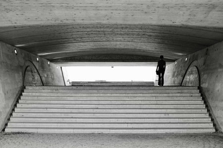 black and white photo of a man walking up the stairs. Leopold Sedar Senghor footbridge in Parisの写真素材