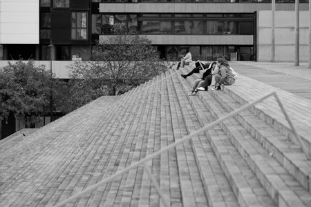 Black and white photo of two girls climbing on the stairs in the city.