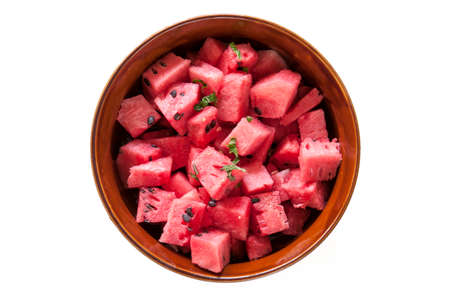 Fresh diced watermelon with mint in bowl isolated on a white background.の写真素材