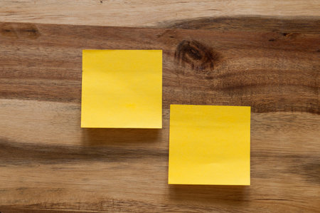 Two stickynote on a wooden background.