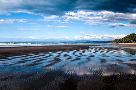 Beautiful reflections on Waiotahe Beach in Opotiki, New Zealandの写真素材