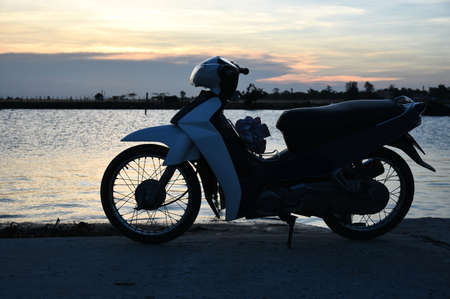 Motorcycle by the sea at sunsetの写真素材