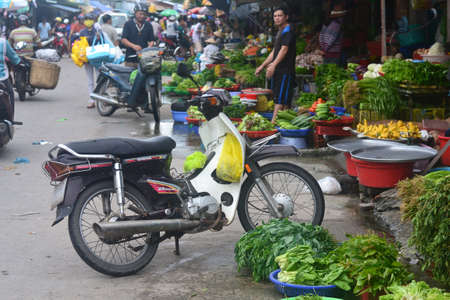Vietnam, Phu Quoc - JULY 26, 2017. Baskets and pelvises with greens, fruits and vegetables, locals buy food, shopping bags hang on a motorcycle.のeditorial素材