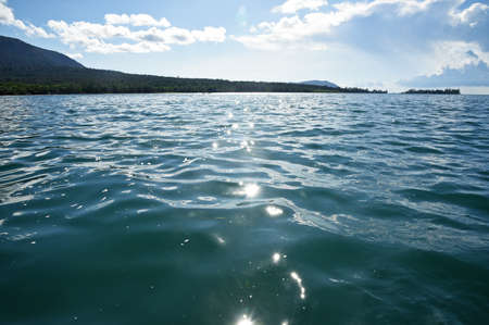 Seascape, view from the sea to the coast, bright sun glare on the wavesの写真素材