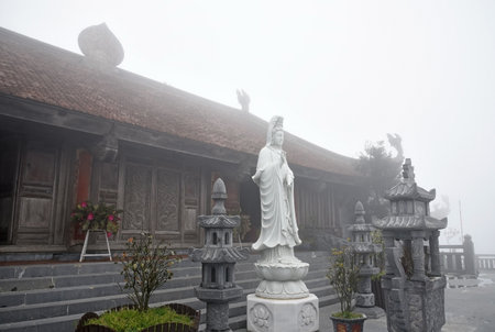 Buddhist temple, Buddha statue and altars on Mount Fansipan in Vietnam during fogの写真素材