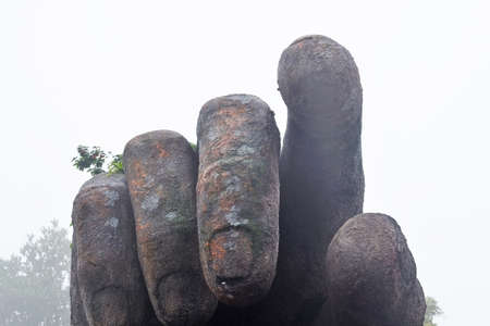 Sculpture of a giant hand, various plants grow on the back of the palm, the index finger points to the viewerの写真素材