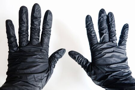 Close up two hands in black gloves on a white background. Stop virus spreading and prevent sickness. Stay safe at home and protect yourself from bacteria. Healthy isolation measures during quarantine.の写真素材