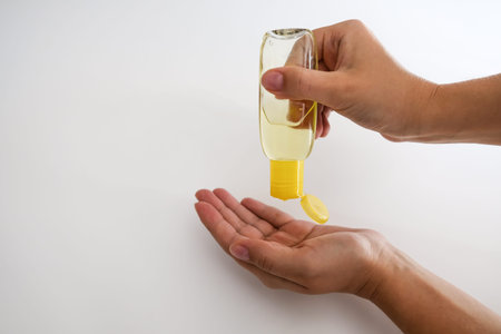 White female hands applying hand sanitizer at home. Woman taking care of herself in isolation during...