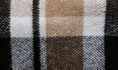 Brown plaid blanket. Close up view of a full size background texture. Textile piece of cloth....