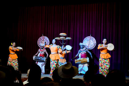 Kandy / Sri Lanka - February 2020: Traditional Sri Lankan performance. Local artists in traditional bright costumes performing on stage. Women dancing with plates and men playing drums.のeditorial素材