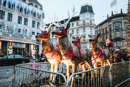Copenhagen / Denmark - November 2019: Reindeer family with Santa Claus sleigh in the main square in Copenhagen. Scandinavian Christmas market decoration in city center. Julemarked Kongens Nytorv.のeditorial素材