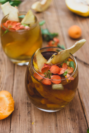drink in a glass with red flowers on a wooden background