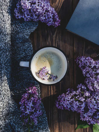 Coffee cup on a wooden background with lilac branchesの写真素材
