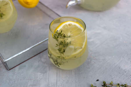 Summer lemon drink with lemon slices on a wooden backgroundの写真素材