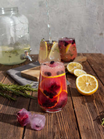 Summer drink with lemon and berries on a wooden backgroundの写真素材