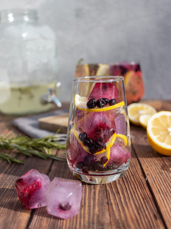 Summer drink with lemon and berries on a wooden backgroundの写真素材