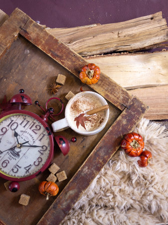 Autumn still life with a cup of coffee and autumn leaves on a wooden background