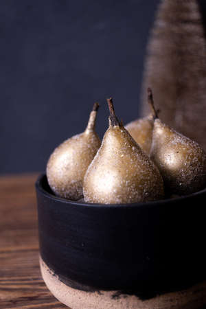 still life with golden pears on a dark backgroundの写真素材