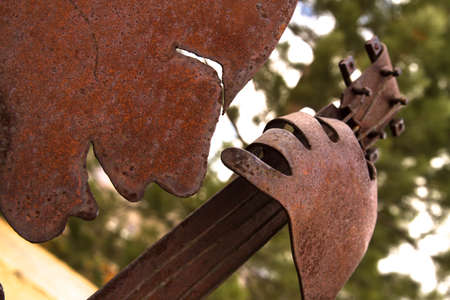 closeup of a rusted sculpture, a musician playing a guitar, carved from a metal sheetの写真素材