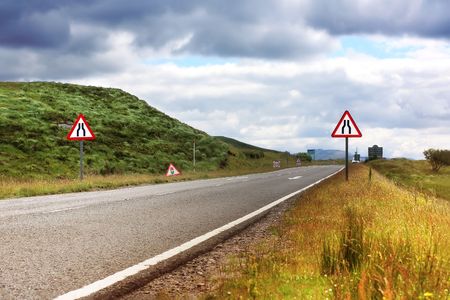 Road with roaD signs in Scotland, summertimeの写真素材
