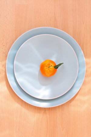 Ripe clementines on the blue, pastel plate, close upの写真素材