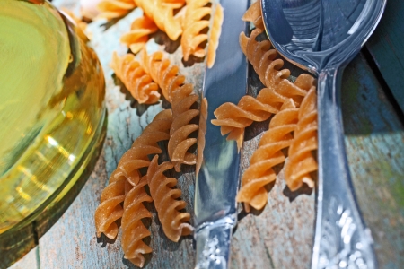 Wholewheat macaroni on the wooden table close upの写真素材
