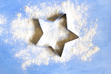 The form for star cookies on blue board with white flourの写真素材