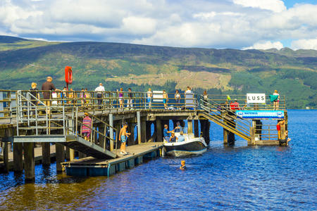 People having fun on a sunny day at the Luss Pier, Loch Lomond, Argylle and bute, Scotlandのeditorial素材