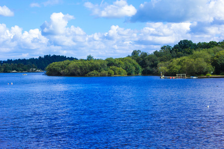 People rowing canoe paddling in calm blue Loch Lomond lake in Scotlandの写真素材