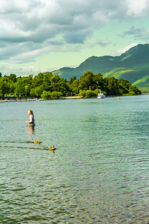 A girl standing in water, Loch Lomond lake in Luss, Scotland, UKのeditorial素材