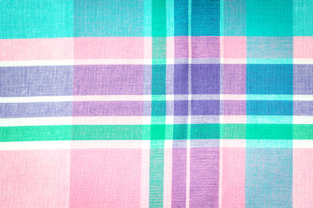 Close up on checkered tablecloth fabric. pink, green, violet with white tartan square patternの写真素材