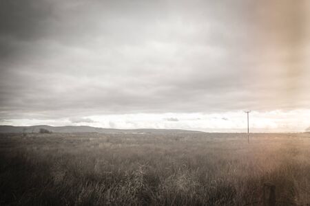 Fantasy rural landscape with fields and blurry skyの写真素材