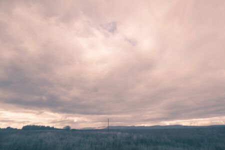 Fantasy rural landscape with fields and blurry skyの写真素材