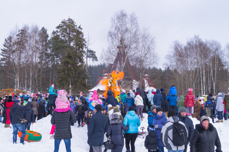 Kostroma, Russia - Febrary 26, 2016: Straw Scarecrow of Shrovetide before burning on Mardi Gras celebration, pancake week. Adults and children celebrate end of winter and beginning of springのeditorial素材